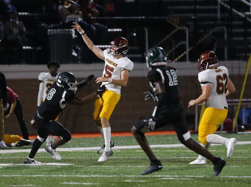 New Hampstead quarterback Pauly Seeley lets go of a pass over Windsor Forest's Trayvon Savage during a 2021 game at Memorial Stadium.