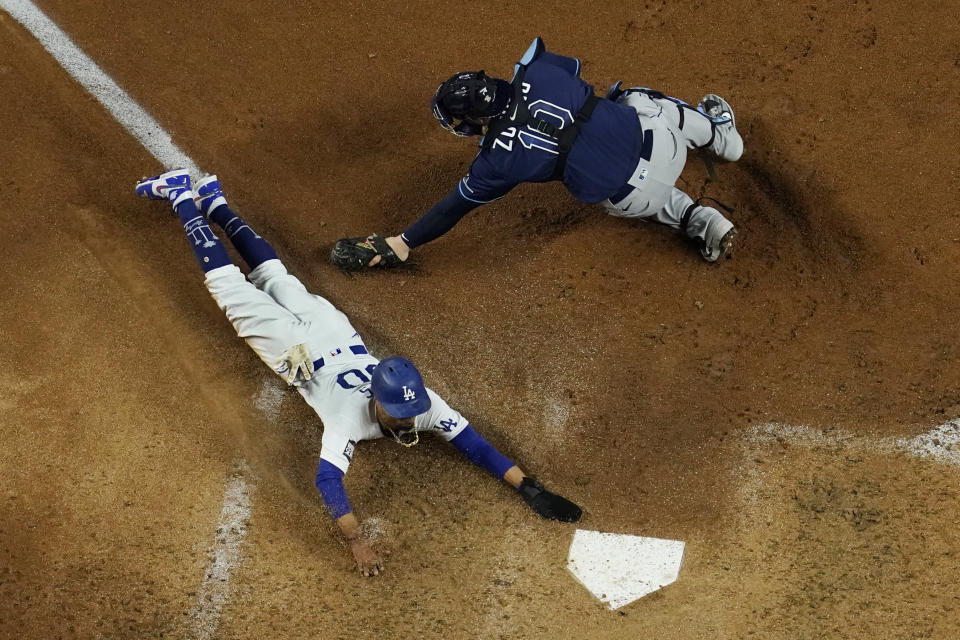 Los Angeles Dodgers' Mookie Betts scores past Tampa Bay Rays catcher Mike Zunino on a fielders choice by Max Muncy during the fifth inning in Game 1 of the baseball World Series Tuesday, Oct. 20, 2020, in Arlington, Texas. (AP Photo/David J. Phillip)
