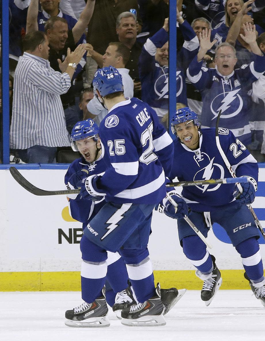 Tampa Bay Lightning right wing Nikita Kucherov (86), of Russia, celebrates with teammates Matt Carle (25) and J.T. Brown after scoring against the Montreal Canadiens during the first period of Game 1 of a first-round NHL hockey playoff series on Wednesday, April 16, 2014, in Tampa, Fla. (AP Photo/Chris O'Meara)