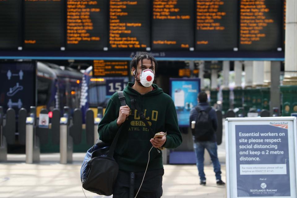 A man walks with a protective face mask on (PA)