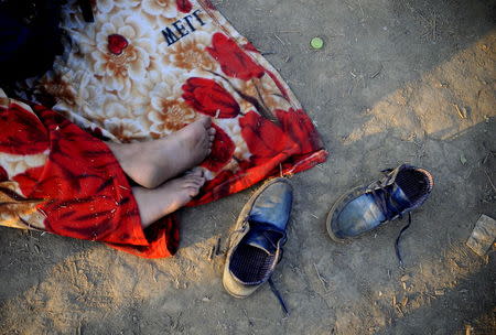 An immigrant, part of a new group of more than a thousand immigrants, sleeps as they wait at the border line of Macedonia and Greece to enter into Macedonia near Gevgelija railway station August 20, 2015. REUTERS/Ognen Teofilovski