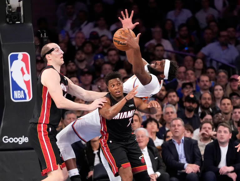 Mitchell Robinson cae sobre Kyle Lowry en la puja por un rebote, ante Cody Zeller, en la victoria de New York Knicks contra Miami Heat que dejó 1-1 su semifinal del Este.