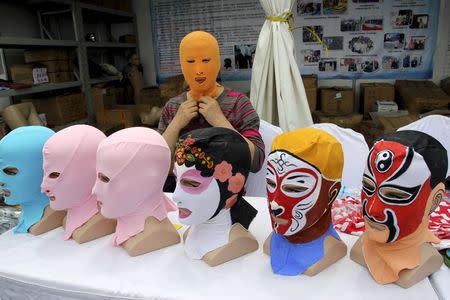 Zhang Shifan tries on a face-kini mask as she demonstrates her products at an exhibition in Qingdao, Shandong province, China, May 22, 2015. REUTERS/Stringer