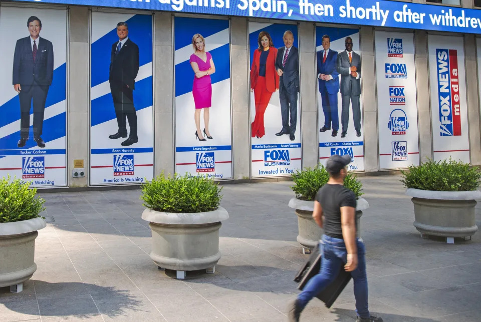 FILE - Images of Fox News personalities, from left, Tucker Carlson, Sean Hannity, Laura Ingraham, Maria Bartiromo, Stuart Varney, Neil Cavuto and Charles Payne appear outside News Corporation headquarters in New York on July 31, 2021. In defending itself against a massive defamation lawsuit over how Fox covered false claims surrounding the 2020 presidential election, the network is relying on a 1964 Supreme Court ruling that makes it difficult to successfully sue media organizations for libel. (AP Photo/Ted Shaffrey, File)