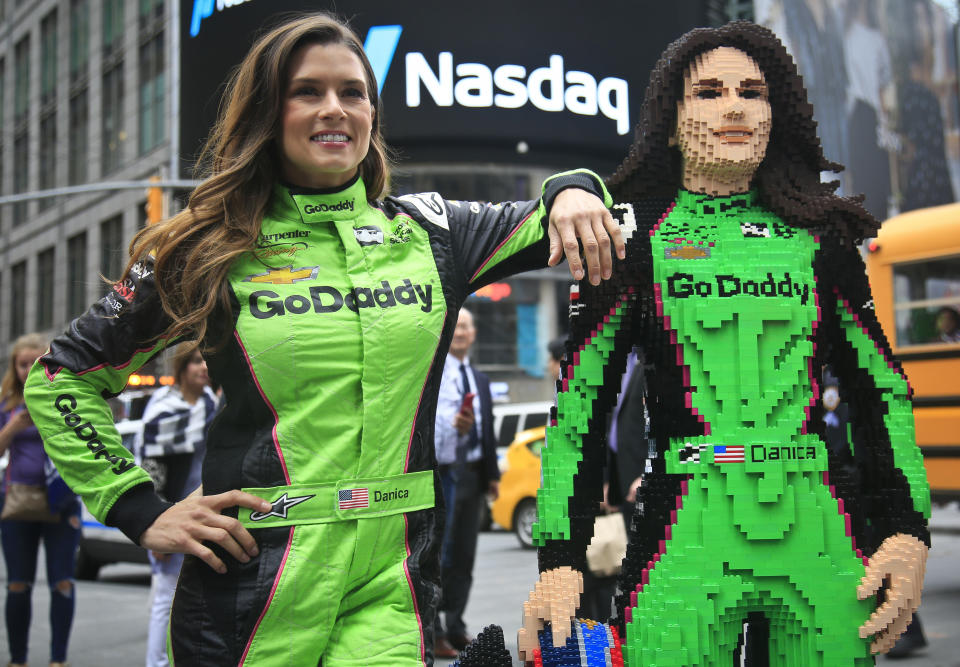 Danica Patrick (L) poses with a life-size Lego statue creation of herself in New York. Lego master builder Chris Steininger says it took him 200 hours to build, using under 15,000 pieces and 13 different colors. (AP)