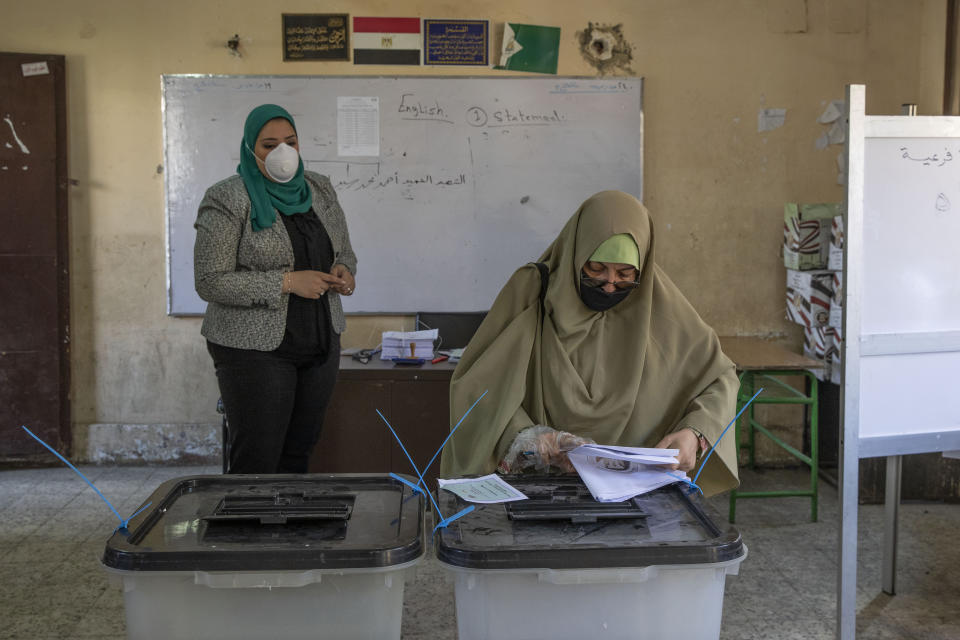 A woman casts her ballot on the first day of the Senate elections inside a polling station in Cairo, Egypt, Tuesday, Aug. 11, 2020. Egyptians started voting on Tuesday for the Senate, the upper chamber of parliament that was revived as part of constitutional amendments approved in a referendum last year — an election that comes as the country faces an uptick in daily numbers of new coronavirus cases. (AP Photo/Nariman El-Mofty)