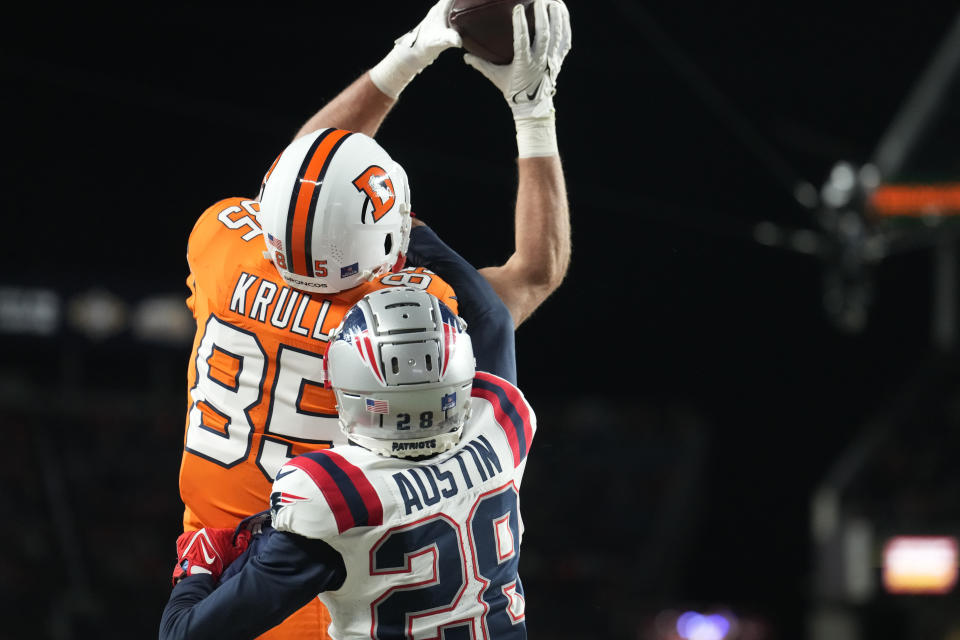 Denver Broncos tight end Lucas Krull (85), defended by New England Patriots cornerback Alex Austin (28), catches a 3-yard pass for a touchdown during the second half of an NFL football game, Sunday, Dec. 24, 2023, in Denver. (AP Photo/David Zalubowski)