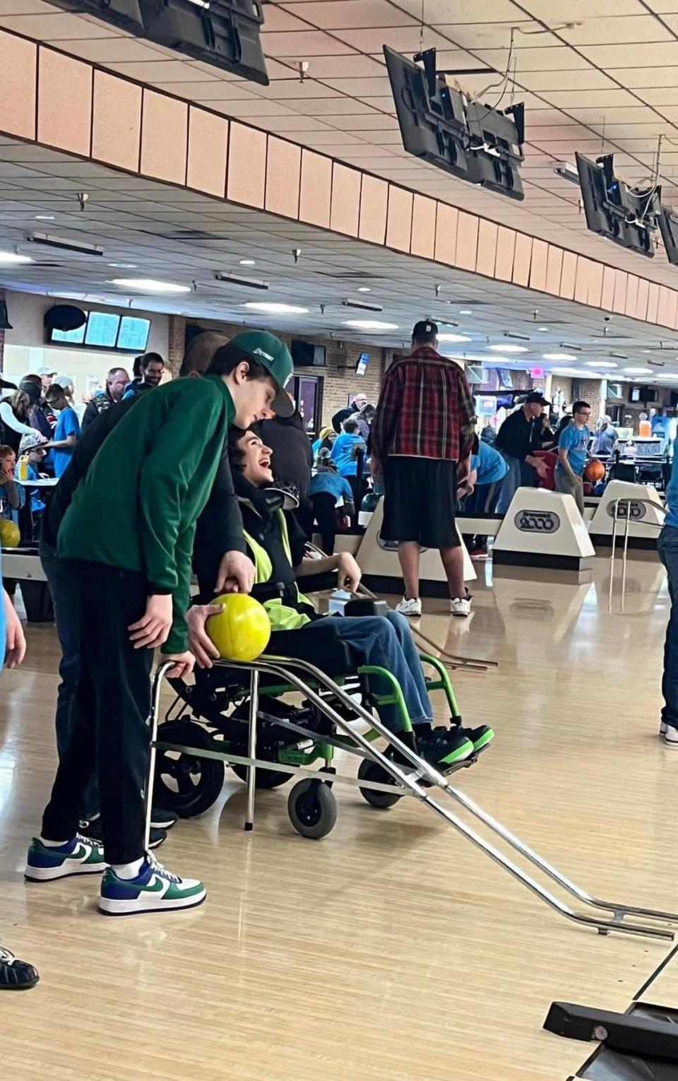 Ozzie Schons, left, of Lake Orion, helps his brother Zander launch a ball down a ramp during Miracle League of North Oakland’s first bowling event of the winter Saturday. The event for special needs kids and young adults went on as planned at Century Bowl in Waterford after a thief absconded with $350 in registration fees.