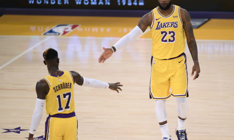 LeBron James daps up new Los Angeles Lakers teammate Dennis Schroder during early 2020-21 game.