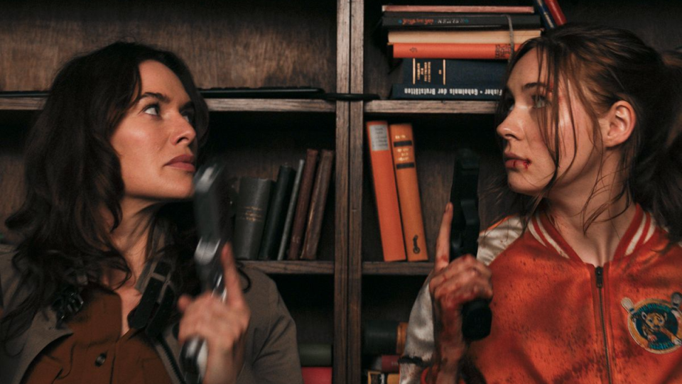 Lena Headey and Karen Gillan wield guns in a library.