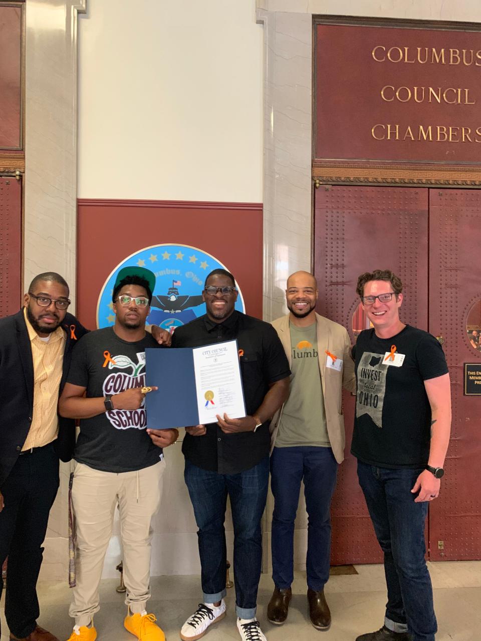 From left, Corey Favor, Malcolm White, Yogi Terrell, Chris Jones and Timothy Wolf Starr pose with Columbus City Council resolutions recognizing 614 Day.