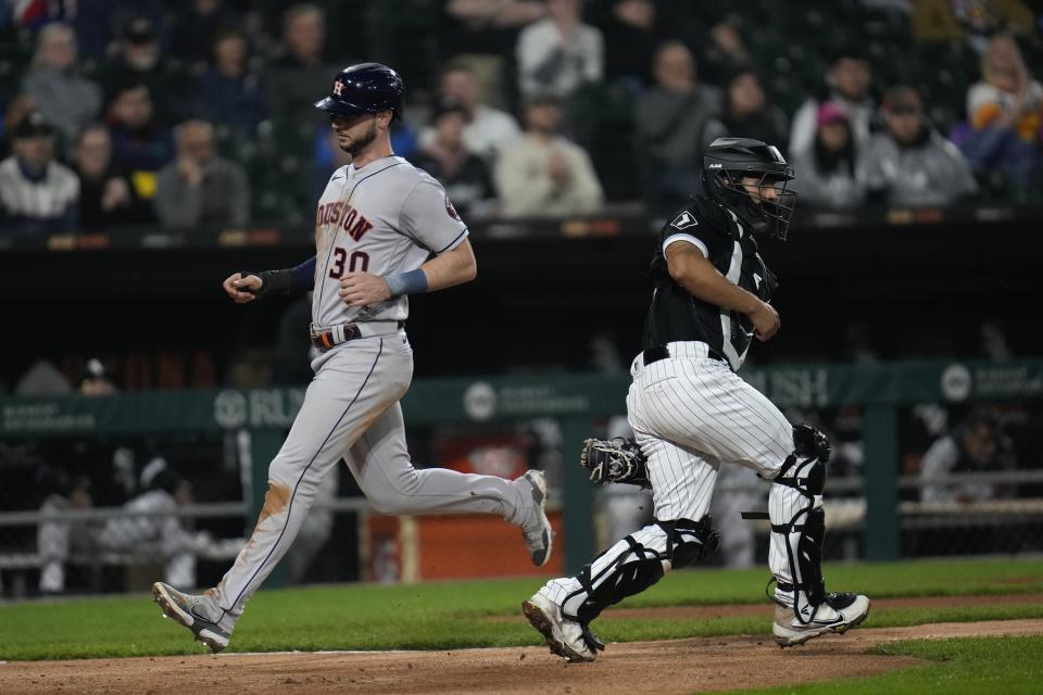 Houston Astros' Kyle Tucker, left, jogs past Chicago White Sox catcher Seby Zavala to score during the fourth inning of a baseball game Friday, May 12, 2023, in Chicago. (AP Photo/Erin Hooley)
