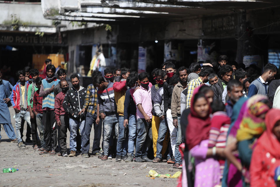Indian passengers who got stranded at a bus terminal line up for free food being distributed by shop keepers during a day long lockdown amid growing concerns of coronavirus in Jammu, India, Sunday, March 22, 2020. India is observing a 14-hour “people's curfew” called by Prime Minister Narendra Modi in order to stem the rising coronavirus caseload in the country of 1.3 billion. India's government has made fervent appeals to the public to practice social distancing, but experts say, the same is nearly impossible in many Indian cities that are among the world's most densely populated areas. For most people, the new coronavirus causes only mild or moderate symptoms. For some it can cause more severe illness. (AP Photo/Channi Anand)