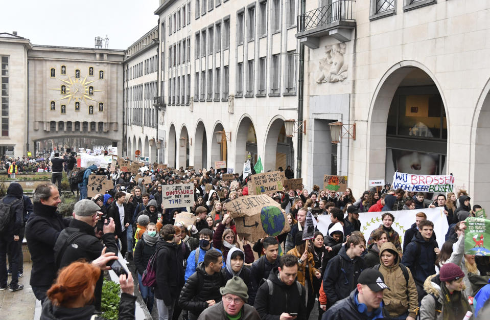 Students and others hold up placards with climate messages during a demonstration against climate change in Brussels, Thursday, Jan. 17, 2019. Thousands of students as part of the Youth for Climate movement took time off school Thursday to call for stronger action against climate change. Banner at right in Dutch reads 'we are truant for more forests' and at center rear reads 'no money if it melts'. (AP Photo/Geert Vanden Wijngaert)