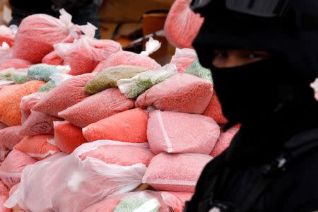 A police officer from the Narcotics Control Board stands guard in front of bags of methamphetamine pills during the 47th Destruction of Confiscated Narcotics ceremony in Ayutthaya province, north of Bangkok, Thailand June 26, 2017. REUTERS/Chaiwat Subprasom