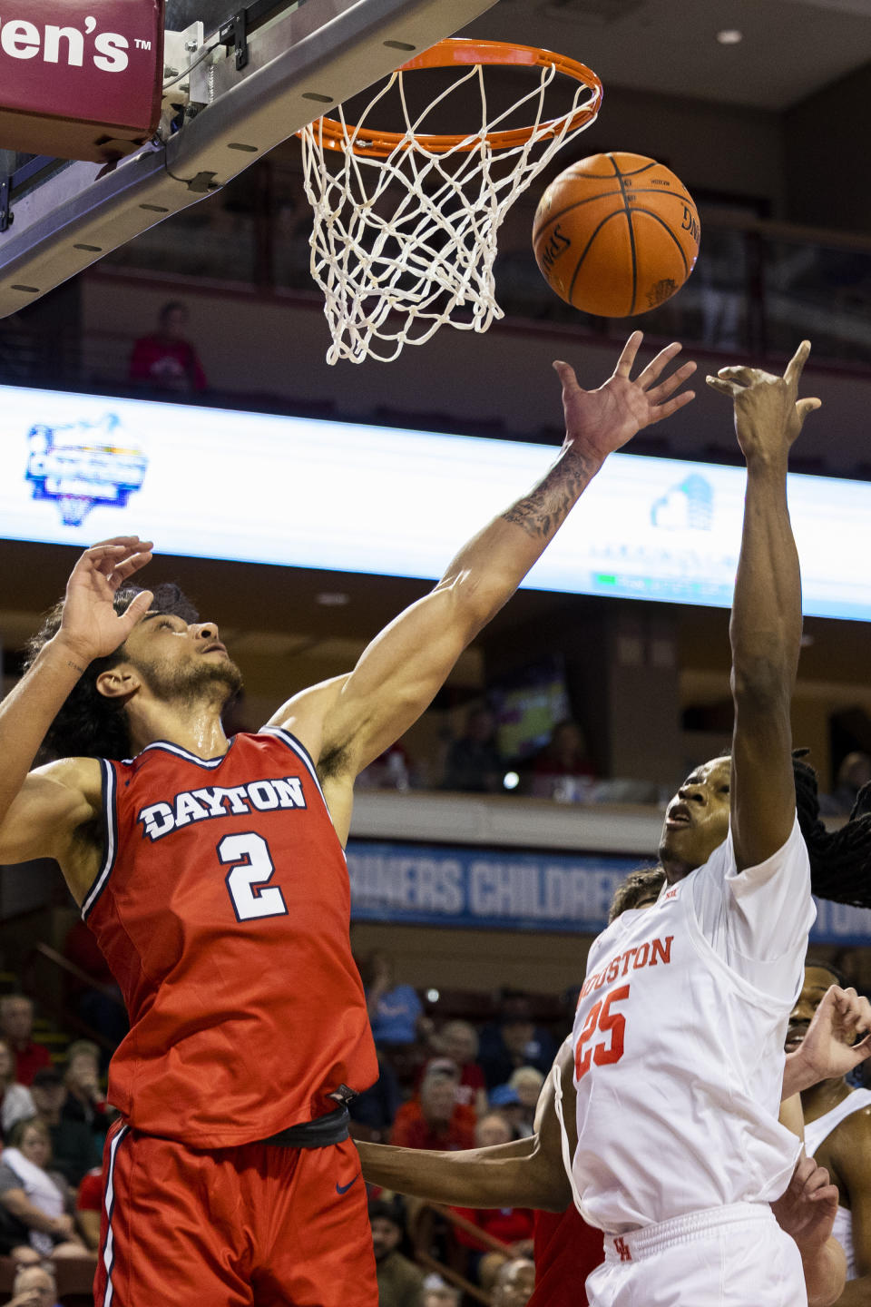 Houston's Joseph Tugler (25) fights for a rebound against Dayton's Nate Santos (2) in the first half of an NCAA college basketball game during the Charleston Classic in Charleston, S.C., Sunday, Nov. 19, 2023. (AP Photo/Mic Smith)