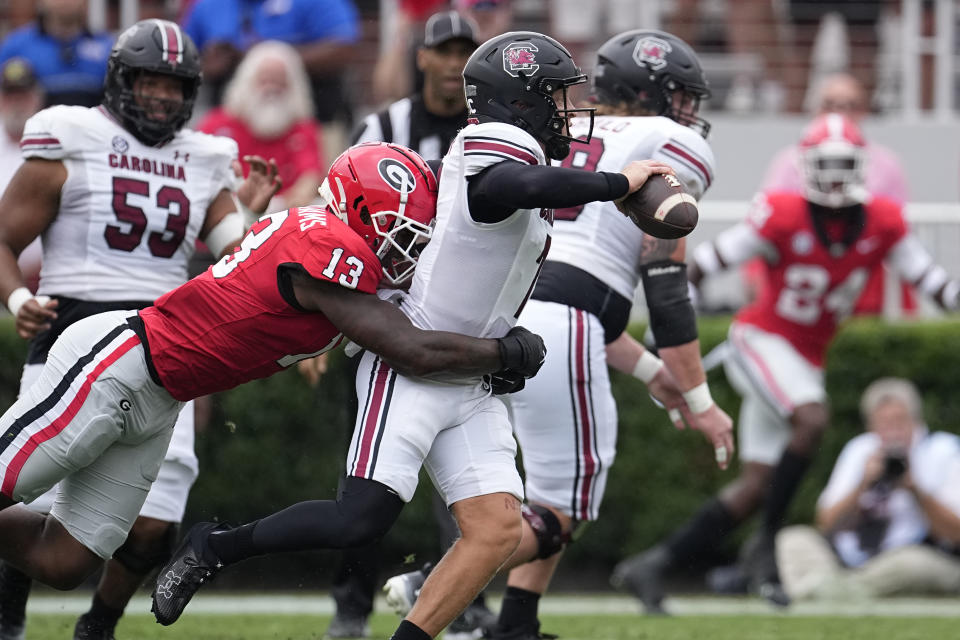 South Carolina quarterback Spencer Rattler (7) is hit by Georgia defensive lineman Mykel Williams (13) as he releases a pass during the first half of an NCAA college football game Saturday, Sept. 16, 2023, Ga. (AP Photo/John Bazemore)