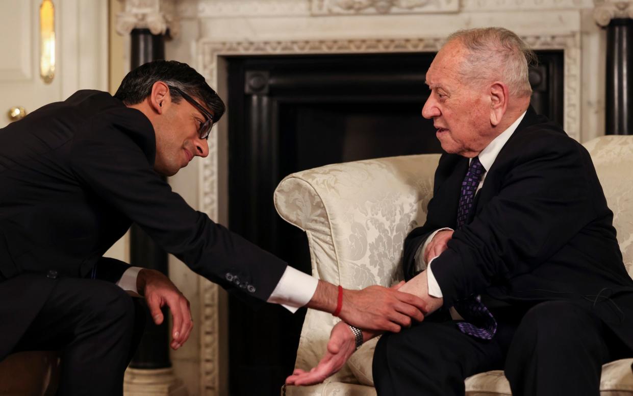 Rishi Sunak looks at the identification number on the arm of Holocaust Surviver Arek Hersh - No10 Downing Street