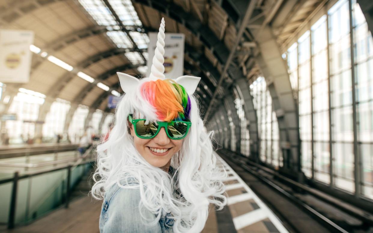 Trot on: a millennial in unicorn headress - Getty Images Contributor