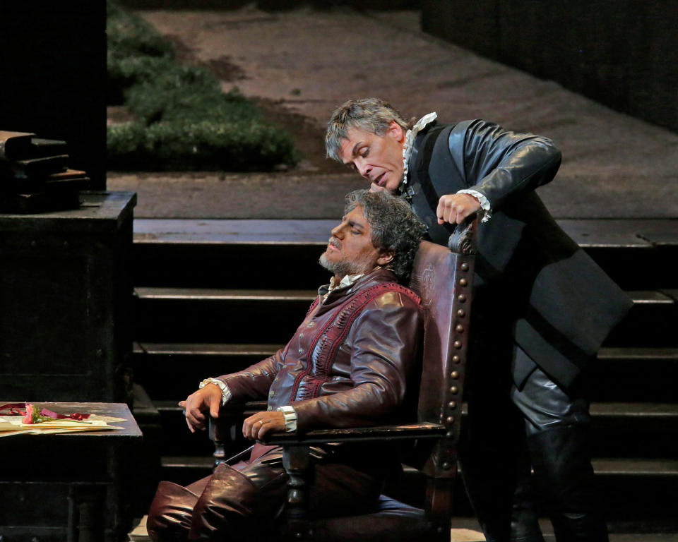 In this March 11, 2013 photo provided by the Metropolitan Opera, Thomas Hampson, right, plays Iago with Jose Cura, seated, in the title role during a performance of of Verdi's "Otello," at the Metropolitan Opera in New York. (AP Photo/Ken Howard)