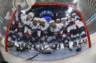 United States players gather in front of the net before a preliminary round women's hockey game against Finland at the 2022 Winter Olympics, Thursday, Feb. 3, 2022, in Beijing. (Jonathan Ernst/Pool Photo via AP)