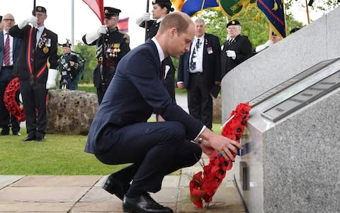 Prince William lays a wreath in the pouring rain - Credit: Anthony Devlin/AFP