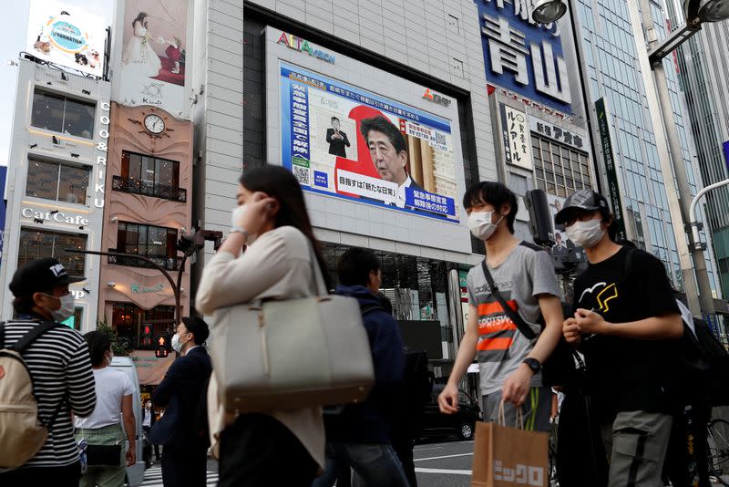 A large screen on a building shows live broadcast of Japan's Prime Minister Shinzo Abe's news conference at Shinjuku district in Tokyo