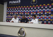 Flanked by Miguel Mejia Baron, UNAM's vice president of sports, left, and Leopoldo Silva, Pumas club president, right, Brazilian Dani Alves signs his contract during a press conference where he was presented as a new member of the Pumas UNAM soccer club, in Mexico City, Saturday, July 23, 2022. (AP Photo/Marco Ugarte)