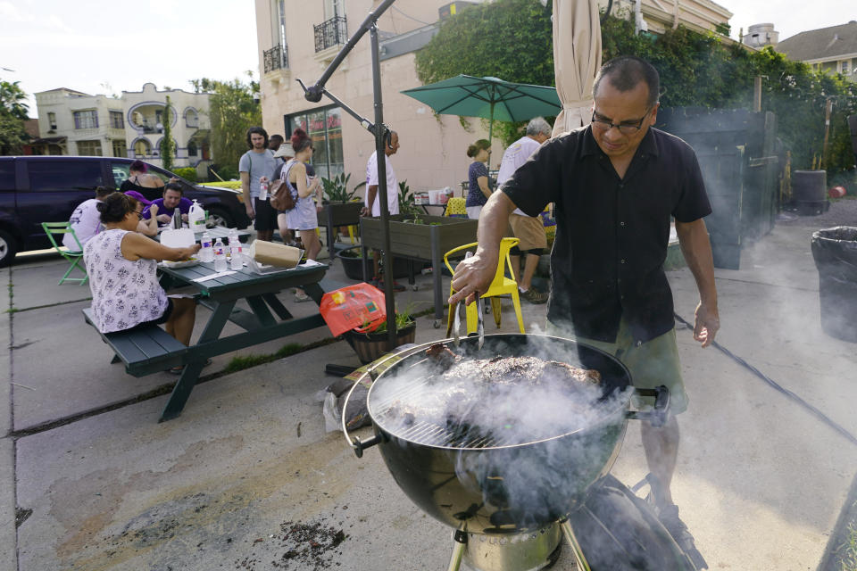 In this Wednesday, Sept. 1, 2021, photo, Mario Aranda grills steak at El Pavo Real restaurant where they served up a free steak taco meal, in New Orleans, La. In New Orleans, food is just one of the many ways that residents help each other during hard times. And it's been no different in the days after Hurricane Ida, which flooded or destroyed homes, tore up trees and knocked out the entire city's power grid.(AP Photo/Eric Gay)