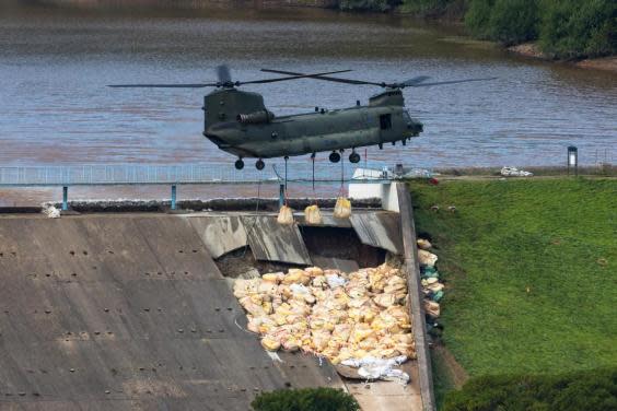 An RAF Chinook helicopter flies in sandbags to help repair the dam at Toddbrook Reservoir near Whaley Bridge (EPA)