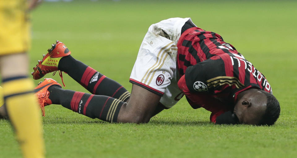 AC Milan's forward Mario Balotelli, lays on the turf after he injured himself in a collision during a round of 16th Champions League soccer match between AC Milan and Atletico Madrid at the San Siro stadium in Milan, Italy, Wednesday, Feb. 19, 2014. (AP Photo/Emilio Andreoli)