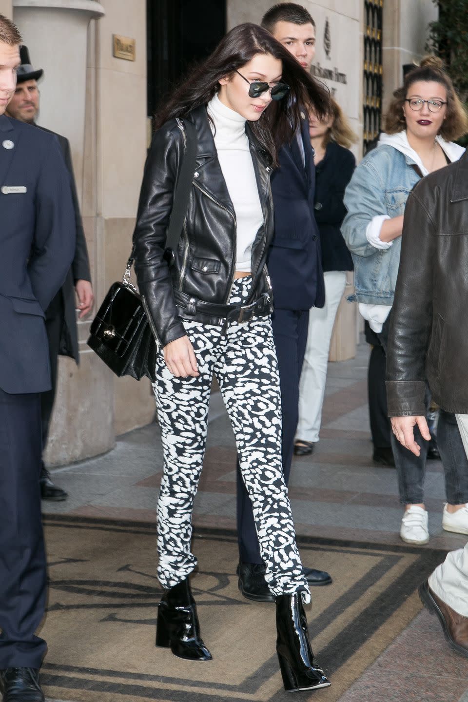 <p>In black and white printed leggings, a white turtleneck, black leather motorcycle jacket, patent leather booties, reflective sunglasses and a structured black handbag while out in Paris. </p>