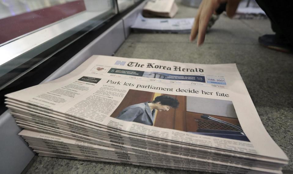 FILE - In this Nov. 29, 2016 file photo, newspapers reporting about South Korean President Park Geun-hye's address to the nation are displayed at a newspaper distributing station in Seoul, South Korea. Impeached President Park Geun-hye’s surname is “Park,” right? Nope. In Korean it’s closer to “Bahk.” Park’s allegedly corrupt confidante, Choi Soon-sil, pronounces her name more like “Chwey” than the way it’s rendered in English. There is a gulf, often a wide one, between the way Koreans write their names in English and the way they actually sound. (AP Photo/Lee Jin-man, File)