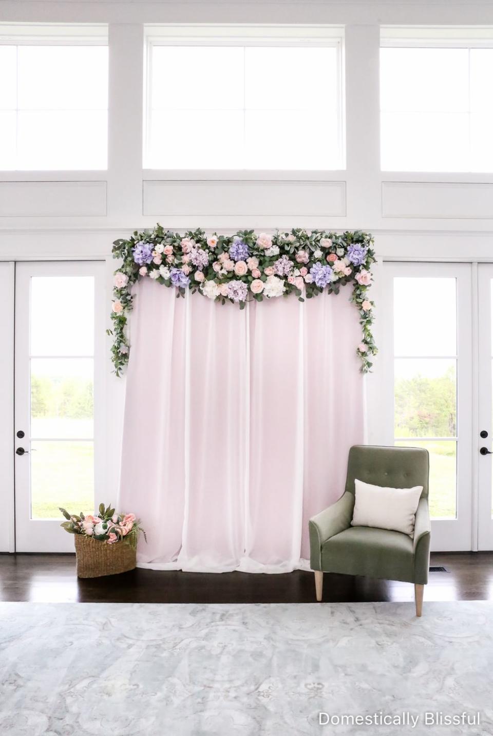 a chair and a table in a room with a window and diy photo backdrop