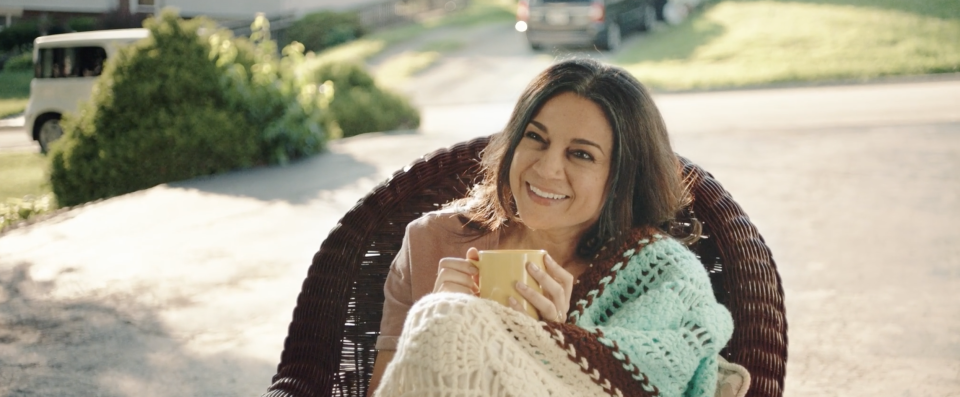 Monica's mom smiling with a cup of tea in her hands