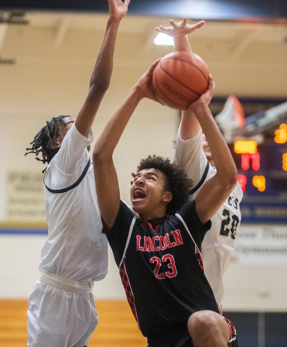 Lincoln's Quentin Thompson, center, goes to the hoop against West's Cameron Williams, left, and Nicolas Rodrigues during a boys varsity basketball game at West High in Tracy on Friday, Jan. 27, 2023. Lincoln won 59-27. 