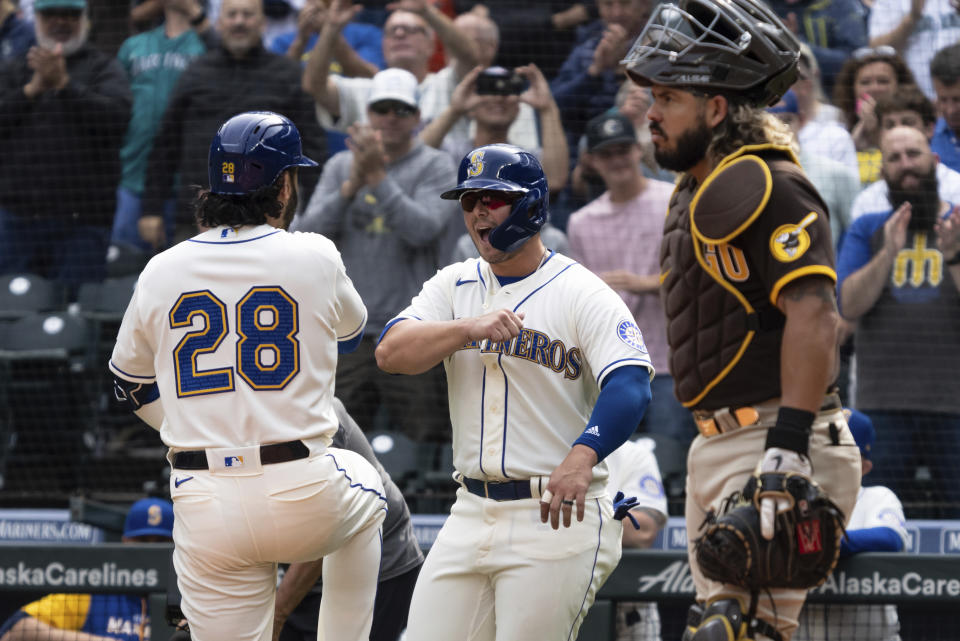 Seattle Mariners' Eugenio Suarez, left, is congratulated by Ty France after hitting a two-run home run off San Diego Padres starting pitcher Mike Clevinger during the first inning of a baseball game, Wednesday, Sept. 14, 2022, in Seattle. (AP Photo/Stephen Brashear)