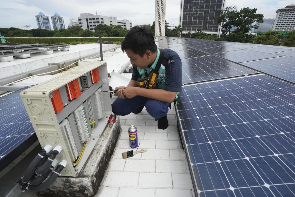 A worker performs maintenance work on solar panels that provide partial electrical power to Istiqlal Mosque in Jakarta, Indonesia, Wednesday, March 29, 2023. A major renovation in 2019 installed upwards of 500 solar panels on the mosque's expansive roof, now a major and clean source of Istiqlal's electricity. (AP Photo/Tatan Syuflana)