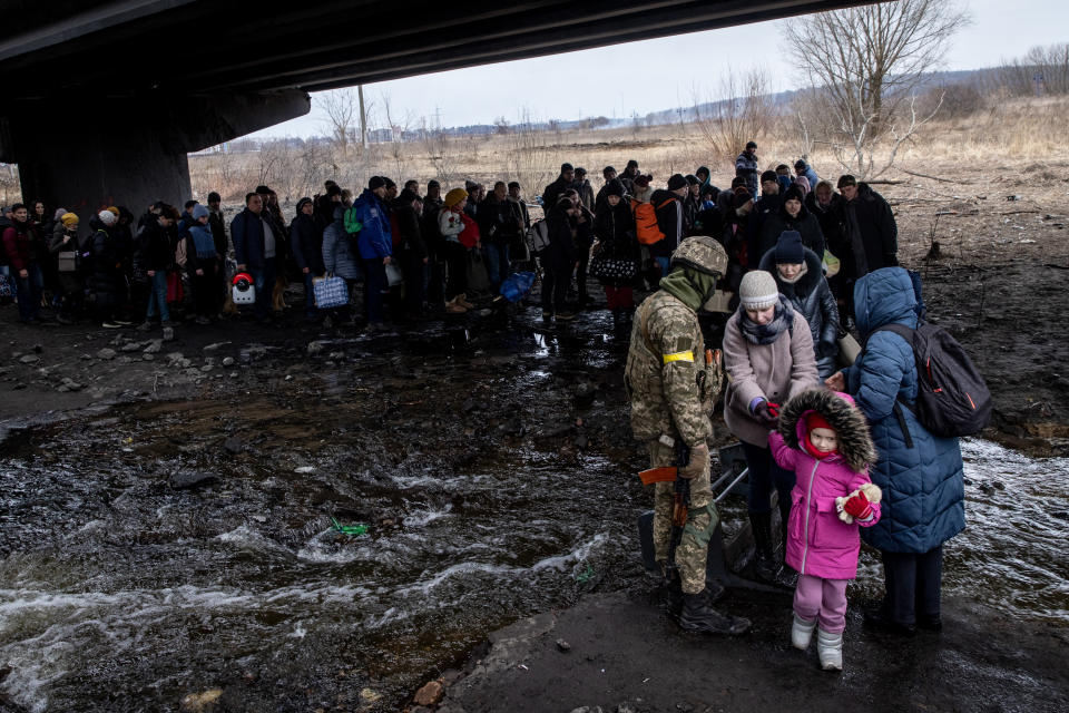 IRPIN, UKRAINE - MARCH 07: Residents of Irpin flee heavy fighting via a destroyed bridge as Russian forces entered the city on March 07, 2022 in Irpin, Ukraine. Yesterday, four civilians were killed by mortar fire along the road leading from Irpin to Kyiv, which has been a key evacuation route for people fleeing Russian forces advancing from the north. Today, Ukraine rejected as 