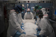 A medical team prepares to rotate a COVID-19 patient in the ICU of the Hospital del Mar, in Barcelona, Spain, Tuesday, Jan. 19, 2021. The unrelenting increase in COVID-19 infections in Spain following the holiday season is again straining hospitals, threatening the mental health of doctors and nurses who have been at the forefront of the pandemic for nearly a year. (AP Photo/Felipe Dana)