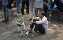 In this Sunday, Sept. 8, 2019, photo, an Indian daily wage construction worker sits on a roadside as he waits to get hired on the outskirts of New Delhi, India. India's economy, once one of the fastest growing in the world, is braking in a blow to the labor-intensive manufacturing sector. Growth slipped to 5% in the April-June quarter, the slowest pace in six years, and many economists believe that Prime Minister Narendra Modi's signature economic policies are at least partly to blame. (AP Photo/Altaf Qadri)