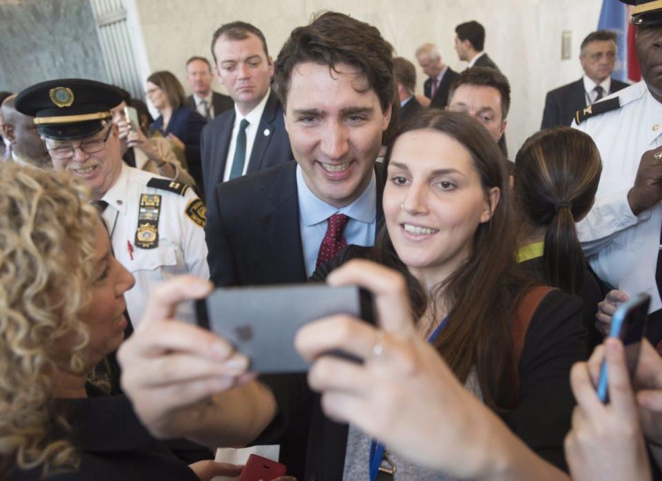 Prime Minister Justin Trudeau poses with a woman for a photo after making remarks as he arrives at the United Nations headquarters in New York, Wednesday, March 16, 2016. THE CANADIAN PRESS/Adrian Wyld