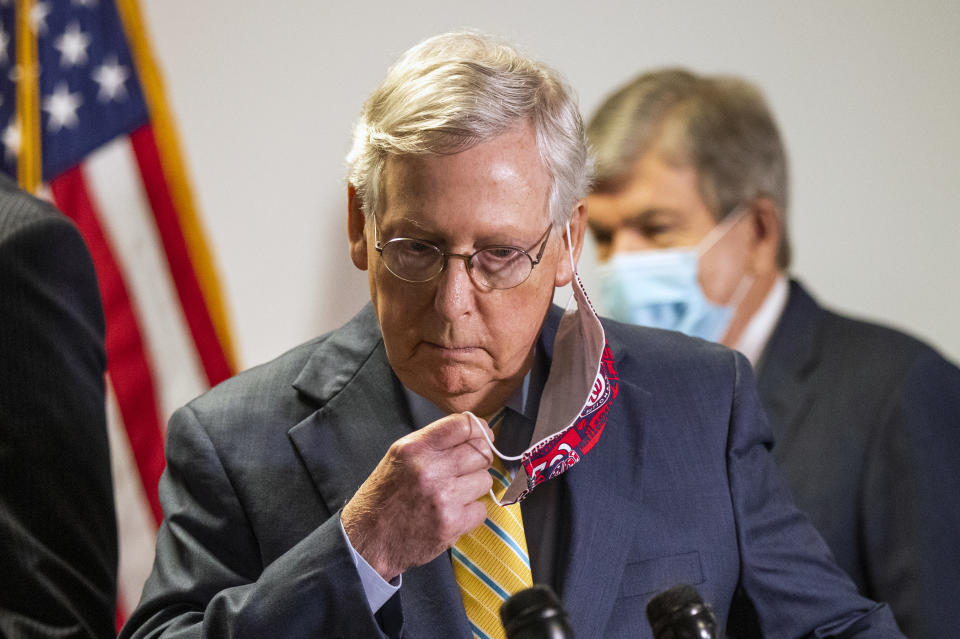 Senate Majority Leader Mitch McConnell, R-Ky., takes off his face mask as he walks toward the podium following a GOP policy meeting on Capitol Hill, Tuesday, June 30, 2020, in Washington. With McConnell is Sen. Roy Blunt, R-Mo. (AP Photo/Manuel Balce Ceneta)