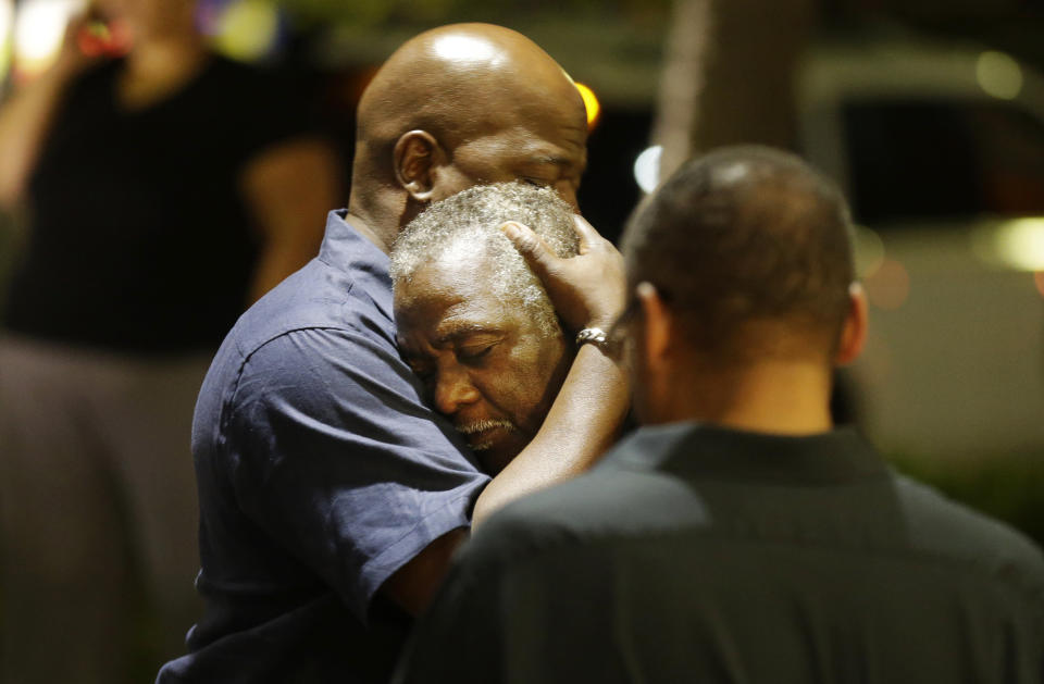 Worshippers embrace following a group prayer across the street from the scene of the shooting. (AP Photo/David Goldman)