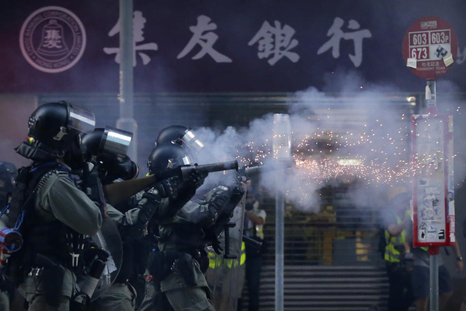In this Saturday, Nov. 2, 2019, file photo, police in riot gear fire tear gas during a protest in Hong Kong. Hong Kong riot police fired multiple rounds of tear gas and used a water cannon Saturday to break up a rally by thousands of masked protesters demanding meaningful autonomy after Beijing indicated it could tighten its grip on the Chinese territory. (AP Photo/Dita Alangkara, File)