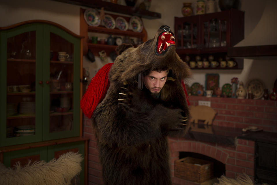 Sergiu, 24 years-old, a member of the Sipoteni bear pack, poses for a portrait in Comanesti, northern Romania, Wednesday, Dec. 27, 2023. Sergiu first wore the bear fur costume when he was 7 years-old says he only feels whole when he wears the outfit and loves the adrenaline rush he gets from hearing the music and dancing with the pack. (AP Photo/Andreea Alexandru)