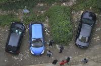 RNPS - PICTURES OF THE YEAR 2013 - Police and bystanders look at a car which is covered with vegetation after it was left parked at a neighbourhood for more than a year, in Chengdu, Sichuan province, October 17, 2013. REUTERS/Stringer (CHINA - Tags: SOCIETY TRANSPORT TPX) CHINA OUT. NO COMMERCIAL OR EDITORIAL SALES IN CHINA