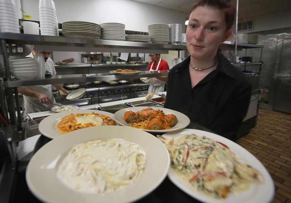 Pasta Al Forno server Annika Taylor carries food to the customers at the restaurant on 13th Street in Ames.