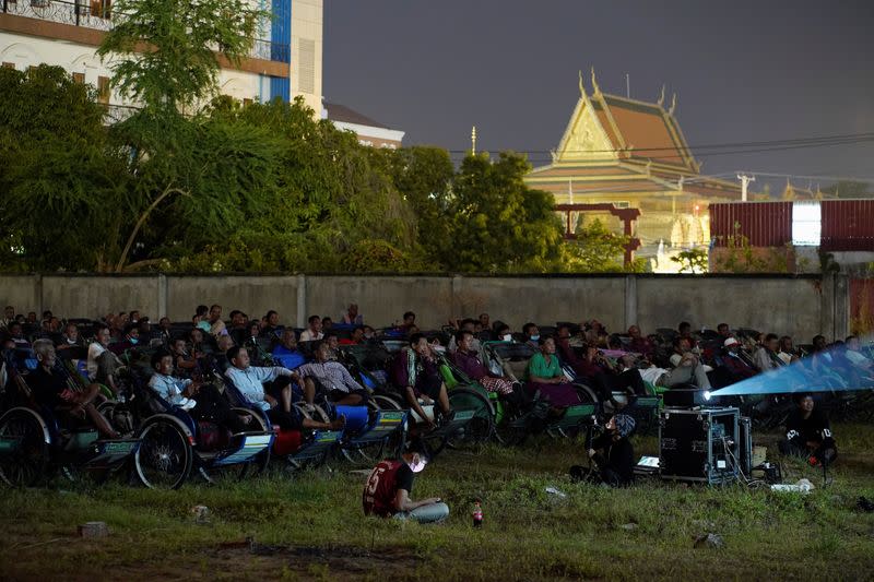 Tricycle drivers attend an outdoor movie screening held by a NGO in Phnom Penh