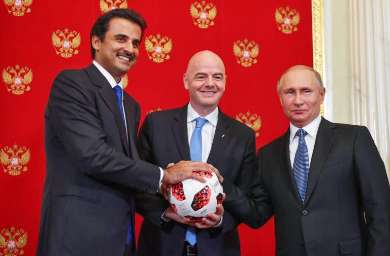 Emir of Qatar Sheikh Tamim bin Hamad Al-Thani poses with FIFA President Gianni Infantino and Russian President Vladimir Putin pose during the symbolic transfer of authority to Qatar by Russia